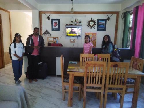 a group of people standing around a table at Orange sky home stay gadaGushaini near jibhi in Jibhi