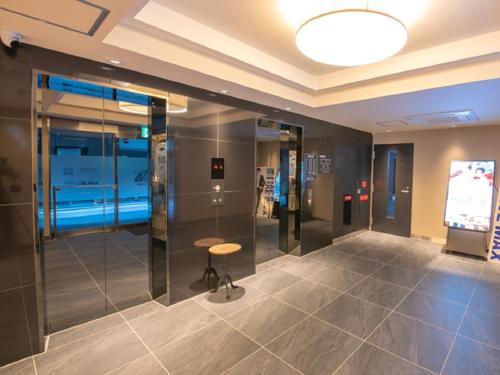 a room with a table and a tv in it at HOTEL LiVEMAX Hakataekimae in Fukuoka