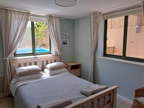 ein Schlafzimmer mit einem Bett mit zwei Kissen darauf in der Unterkunft Desert Rose in Midreshet Ben Gurion