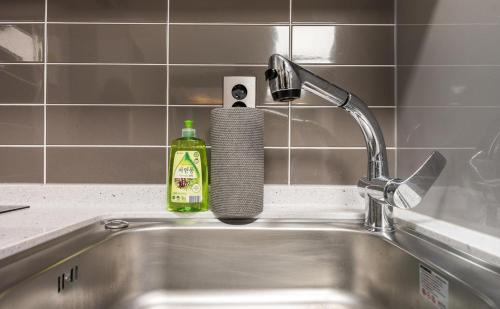 a kitchen sink with a bottle of soap next to it at Songjeong Blue Castle Hotel in Busan