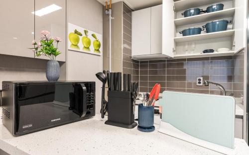 a kitchen counter with a microwave on top of it at Songjeong Blue Castle Hotel in Busan