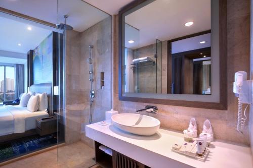 a bathroom with a sink and a glass shower at Grand Mercure Jakarta Kemayoran in Jakarta