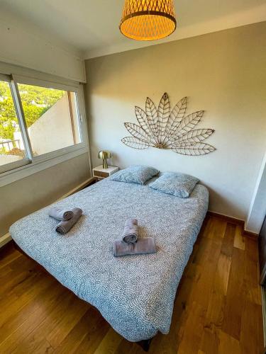 une chambre avec un lit avec deux pantoufles dessus dans l'établissement AZUR - Vue mer - Parking - Climatisation, à Cassis