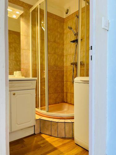 La salle de bains est pourvue d'une douche et d'une baignoire. dans l'établissement AZUR - Vue mer - Parking - Climatisation, à Cassis
