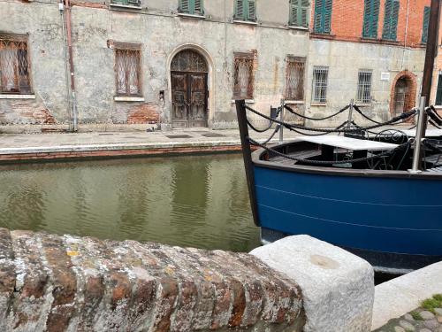 a blue boat is docked next to a building at La casa di Celeste B&B in Comacchio