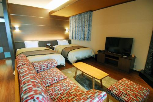 a hotel room with two beds and a couch at Arima Onsen Taketoritei Maruyama in Kobe