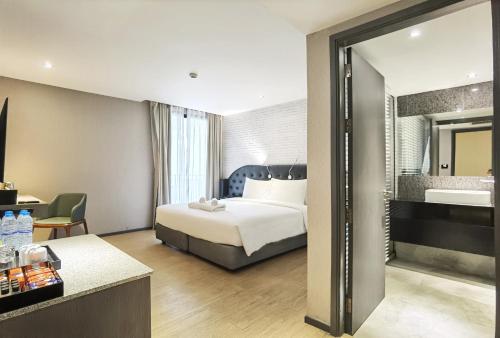 a hotel room with a bed and a bathroom at Citrus Grande Hotel Pattaya by Compass Hospitality in Pattaya South