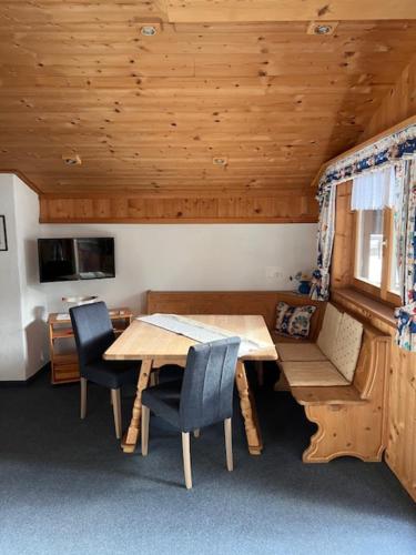 - une salle à manger avec une table et des chaises en bois dans l'établissement Ferienwohnung Gleirscher, à Neustift im Stubaital