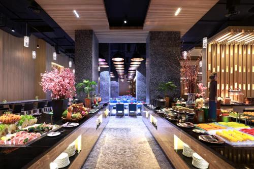 a buffet line of food in a restaurant at Grand Mercure Jakarta Kemayoran in Jakarta