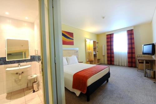 a hotel room with a bed and a bathroom at Bes Hotel Bergamo Ovest in Mozzo