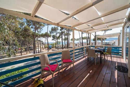 a balcony with a table and chairs and a view of the ocean at Camping Europa in Capoliveri