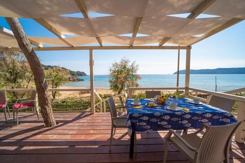 a table on a deck with a view of the ocean at Camping Europa in Capoliveri