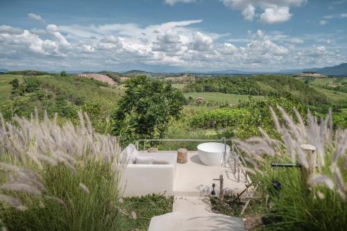 a bathroom with a bath tub in the middle of a field at Sala Khaoyai in Wangkata