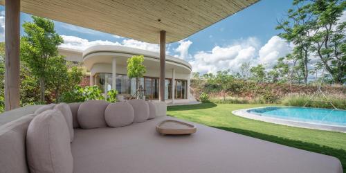 a living room with a couch and a swimming pool at Sala Khaoyai in Wangkata