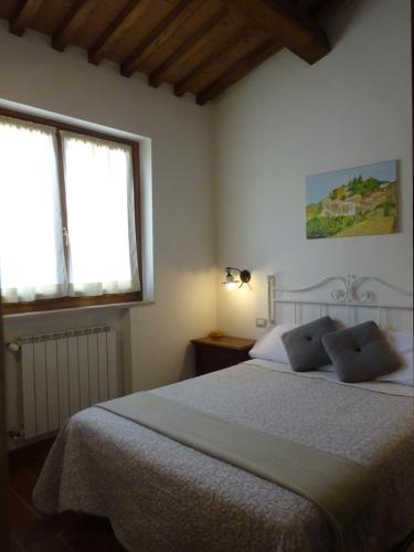a bedroom with a large bed with two windows at I TRE POETI in Saturnia