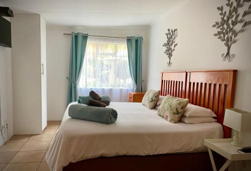 um quarto com uma cama grande com almofadas em La Bella B&B Under The Fig Tree em Bela-Bela