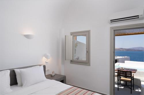 a bedroom with a bed and a view of the ocean at Hotel Goulielmos in Akrotiri