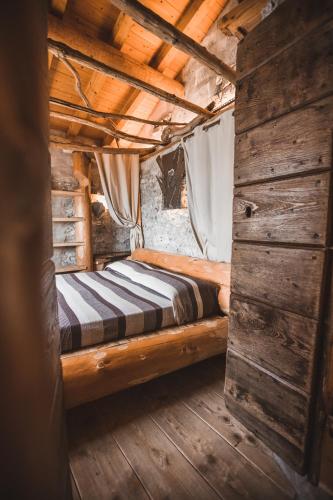 a bed in a wooden room in a cabin at Appartamenti montemezzo le case in pietra Vista lago in Gera Lario