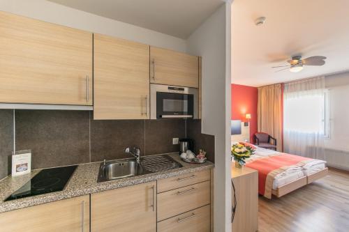 a kitchen with a sink and a bed in a room at Bon Port in Montreux