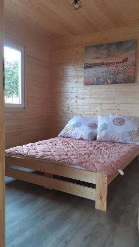 Domek wypoczynkowy nad Jez. Dadaj في بيسكوبييت: غرفة نوم بسرير كبير في غرفة خشبية