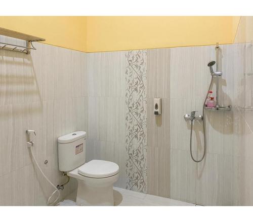 a bathroom with a toilet and a shower at RedDoorz Syariah near RSUD Kota Malang in Bareng