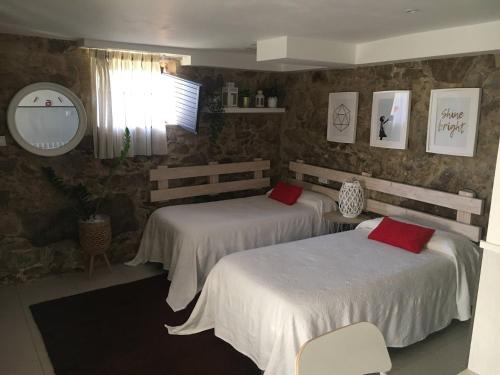 um quarto com 2 camas e almofadas vermelhas em Casa Carola em Oia