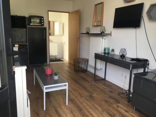 un salon avec une table et une télévision dans l'établissement Studio Pessac, à Pessac