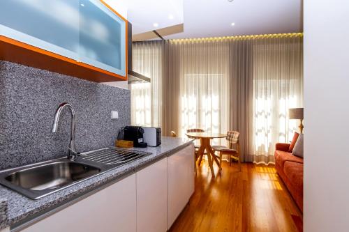 a kitchen with a sink and a living room at Mouzinho 129 - Sobreiro in Porto