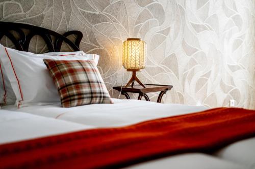 a bed with a pillow and a lamp on a table at Mouzinho 129 - Sobreiro in Porto
