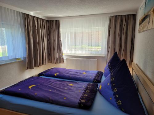 ツィノヴィッツにある2-Raum Ferienwohnungのベッドルーム1室(紫のシーツと枕が備わるベッド1台付)