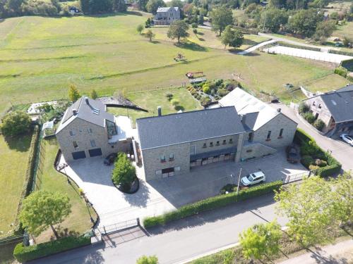 - une vue aérienne sur une grande maison avec une cour dans l'établissement Cha Cha de Loup, à Rendeux