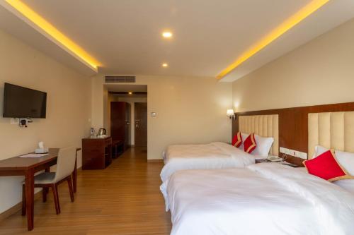 Postel nebo postele na pokoji v ubytování Gorkha Garden Hotel