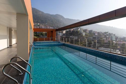 a swimming pool on the balcony of a building at Gorkha Garden Hotel in Gorkhā