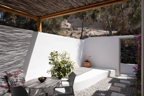 a white patio with a table and chairs at Hotel Goulielmos in Akrotiri
