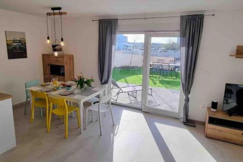 uma sala de jantar com uma mesa e cadeiras amarelas em Gemütliches Ferienhaus mit Whirlpool & Dachterrasse em Privlaka