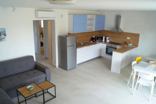 uma cozinha e uma sala de estar com um sofá e uma mesa em Gemütliches Ferienhaus mit Whirlpool & Dachterrasse em Privlaka