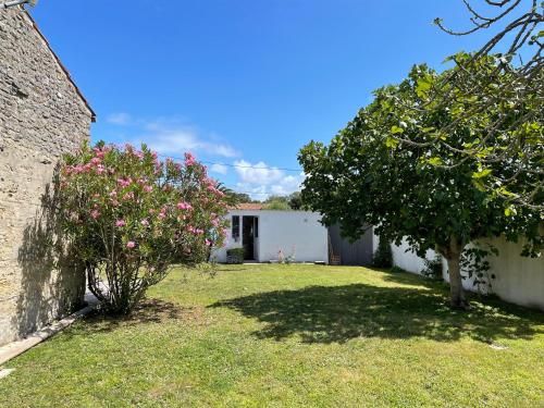 ein Haus mit einem Garten mit Blumen und einem Baum in der Unterkunft La Tranquille - Maison pour 3 familles in La Michelière