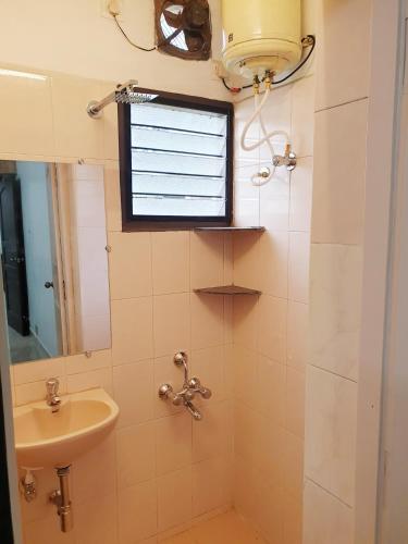 a bathroom with a sink and a window at Chippy Apartments No.27 in Chennai