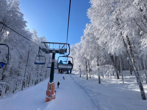 a ski lift with people on it in the snow at Stone House Ilovemajella in Pretoro