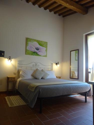 a bedroom with a bed with a flower on the wall at I TRE POETI in Saturnia