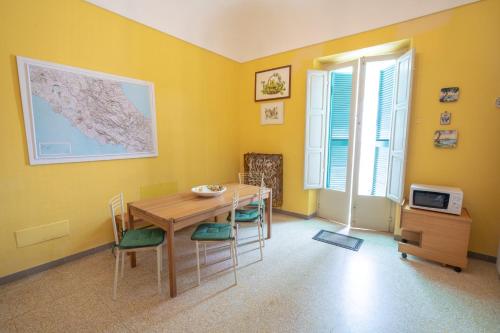 a dining room with yellow walls and a table and chairs at Il Giardino Nascosto B&B in Vasto