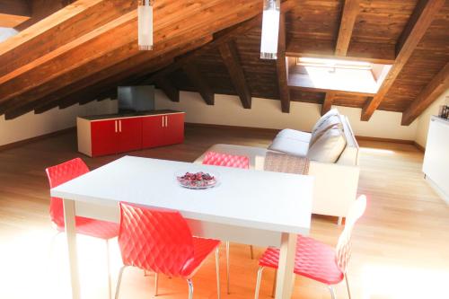 a dining room with a white table and red chairs at My Loft in Ferrara