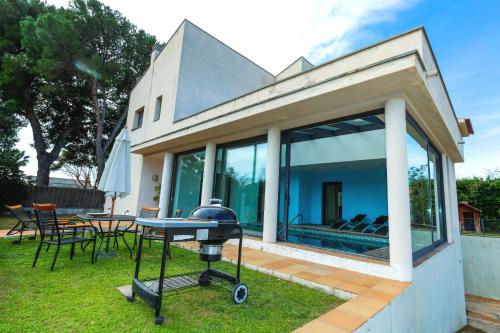 een barbecue in de achtertuin van een huis bij Villa Girasol piscina climatizada Planet Costa Dorada in Vilafortuny