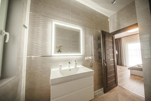 a bathroom with a white sink and a mirror at Kintų Perlas Villa 4 in Kintai