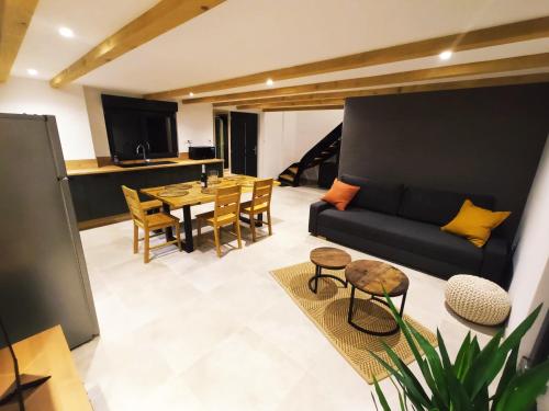 un salon avec un canapé et une table dans l'établissement Gîte des trois châteaux, à Husseren-les-Châteaux