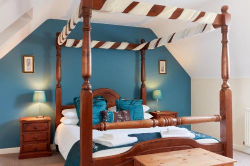 a bedroom with a canopy bed with blue walls at Finest Retreats - Meadow View in Ashbourne