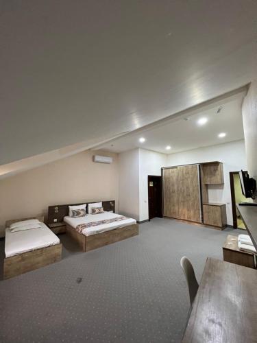 a large room with two beds and a table at Mahmud Hotel in Samarkand