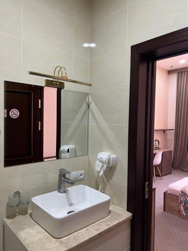 a bathroom with a sink and a mirror at Mahmud Hotel in Samarkand