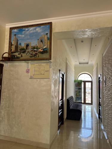 a hallway with a painting on the wall and a couch at Mahmud Hotel in Samarkand