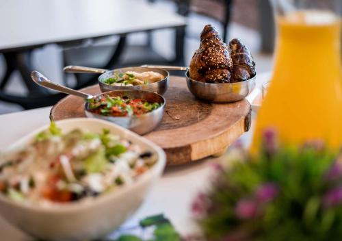 a table with dishes of food and a drink at Lavi Kibbutz Hotel in Lavi